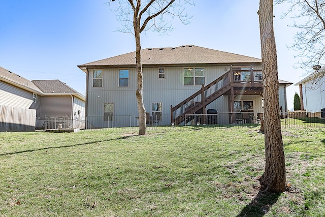 rear view of property featuring a wooden deck, stairs, a yard, and fence