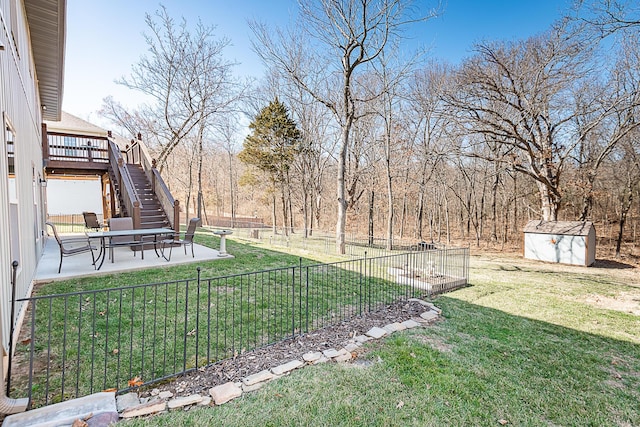 view of yard with a patio, stairway, a fenced backyard, an outdoor structure, and a storage unit