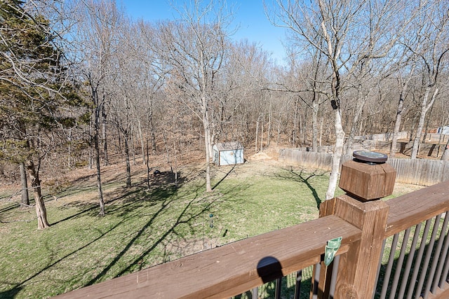 wooden deck featuring an outdoor structure, a storage shed, and a yard