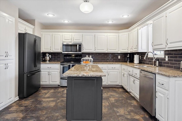 kitchen with a sink, stainless steel appliances, backsplash, and white cabinets