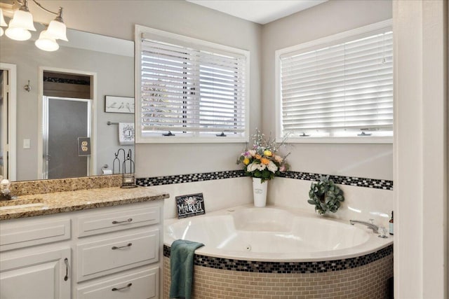 full bath featuring vanity, a shower stall, a bath, and a healthy amount of sunlight