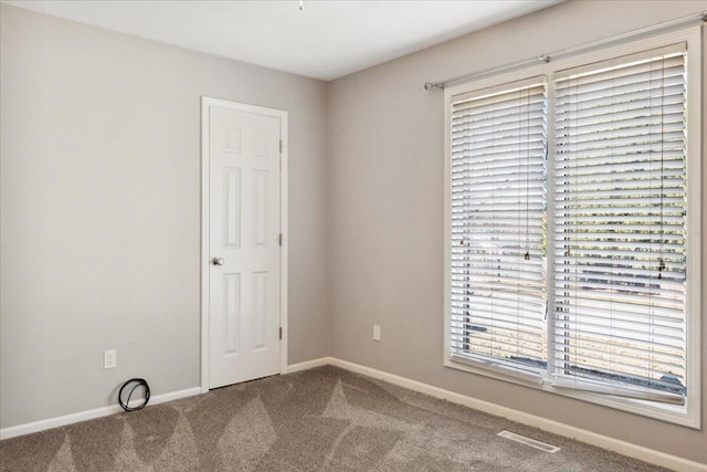 unfurnished room with visible vents, carpet flooring, and baseboards