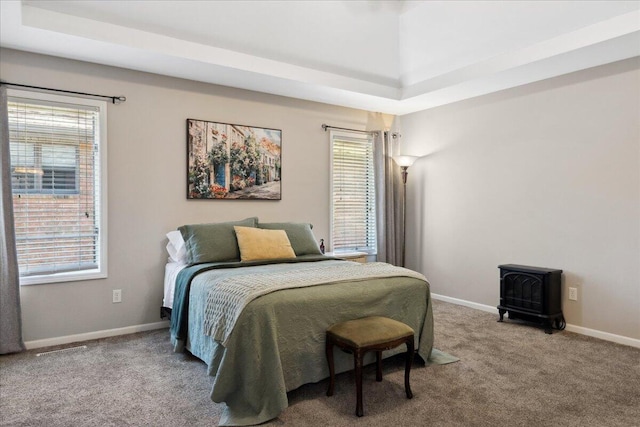 bedroom featuring a wood stove, baseboards, and carpet floors