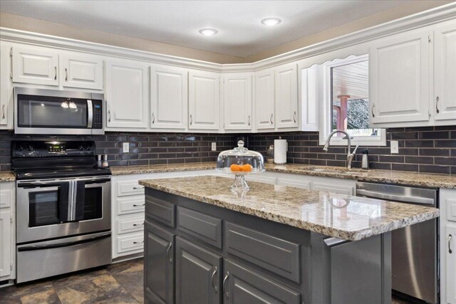 kitchen featuring white cabinetry, gray cabinets, appliances with stainless steel finishes, and a sink