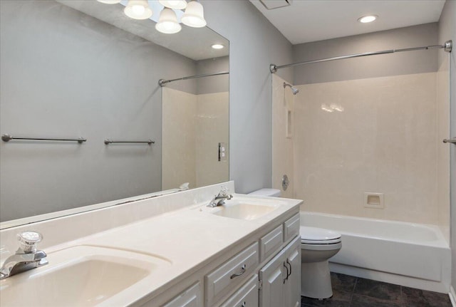 bathroom featuring double vanity, washtub / shower combination, toilet, and a sink