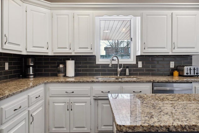 kitchen featuring dishwasher, white cabinets, and a sink