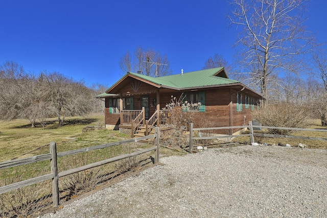 chalet / cabin with a porch, driveway, and metal roof