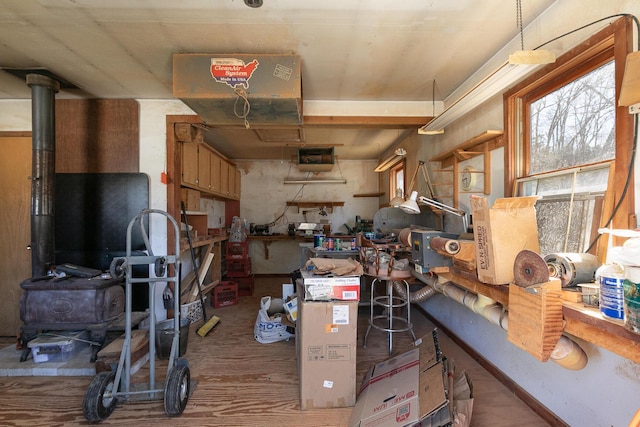 interior space featuring a workshop area, wood finished floors, and a wood stove