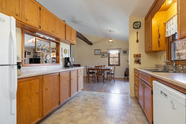 kitchen featuring a sink, white appliances, lofted ceiling, and light countertops