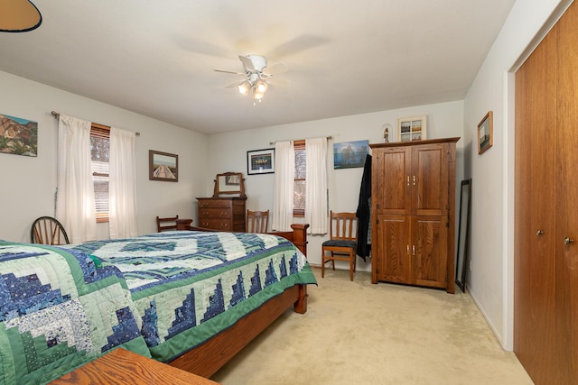 bedroom featuring ceiling fan, multiple windows, and light carpet