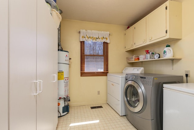 laundry room with light floors, baseboards, separate washer and dryer, cabinet space, and water heater