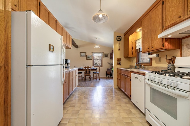 kitchen with brown cabinets, under cabinet range hood, white appliances, light countertops, and vaulted ceiling