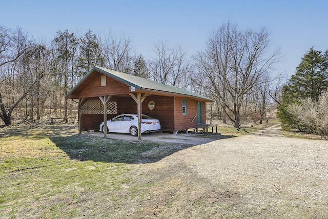 view of front of property with a detached carport, metal roof, and dirt driveway