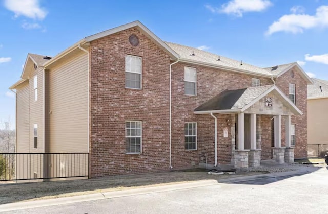 exterior space featuring fence and brick siding