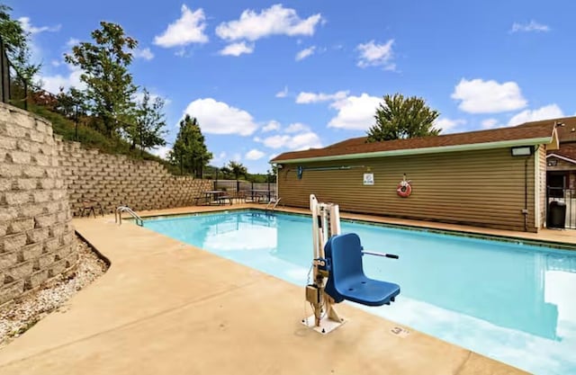 view of swimming pool with a patio area, a fenced in pool, and fence