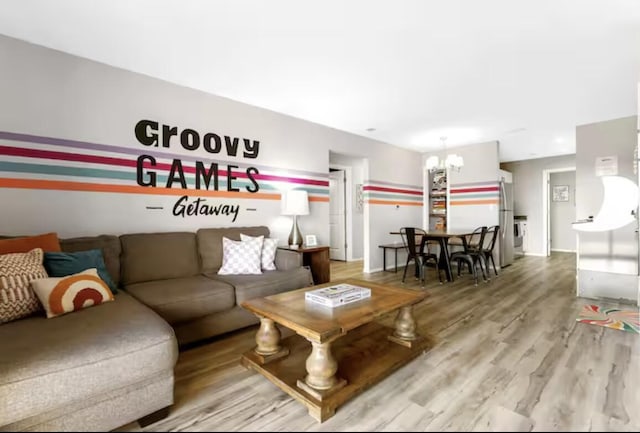 living room featuring baseboards, an inviting chandelier, and wood finished floors