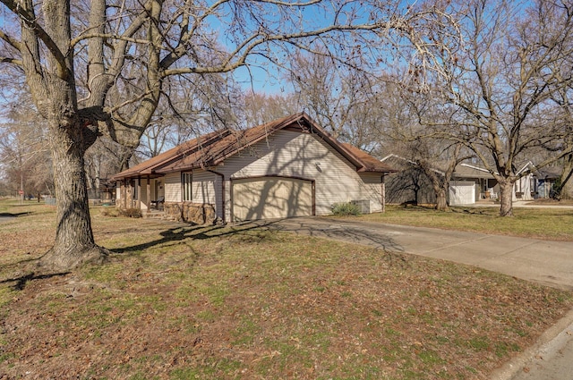 view of front of house with a garage, concrete driveway, and a front lawn