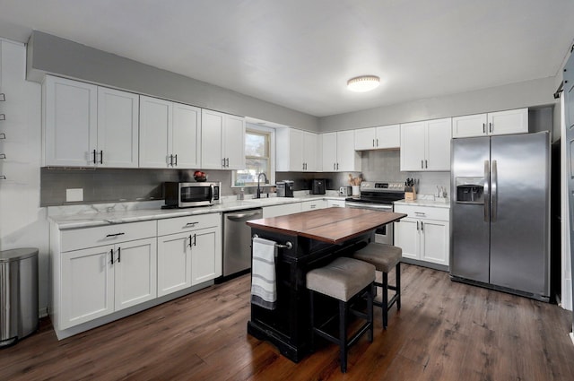 kitchen with a sink, dark wood-type flooring, white cabinetry, and stainless steel appliances