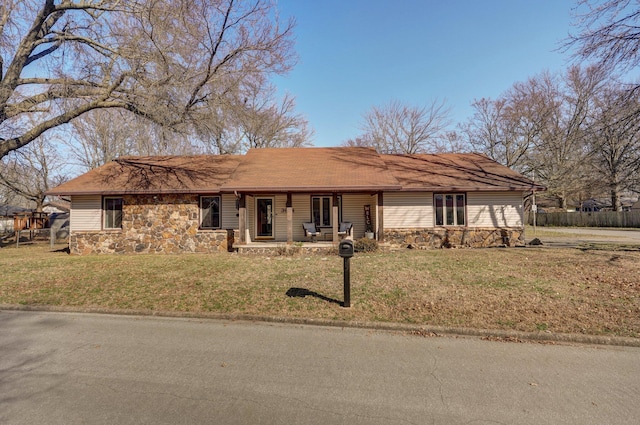 single story home with stone siding, covered porch, and a front lawn