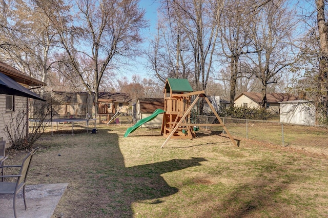 view of jungle gym featuring a trampoline, a lawn, and fence