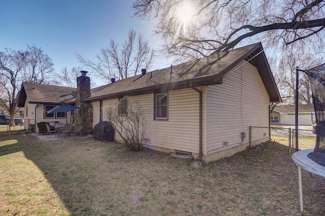 rear view of house featuring a patio, a lawn, and fence