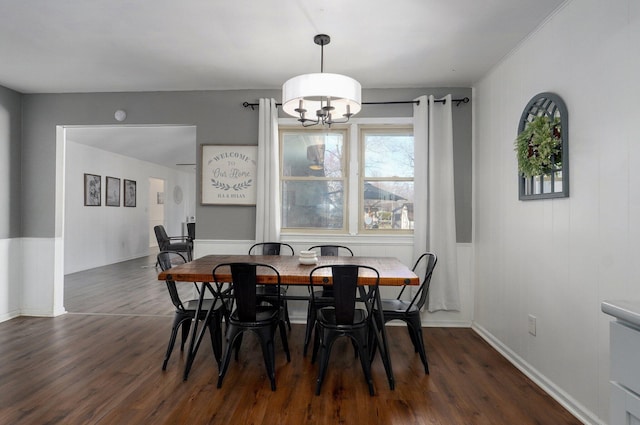 dining space featuring an inviting chandelier, dark wood-type flooring, and baseboards