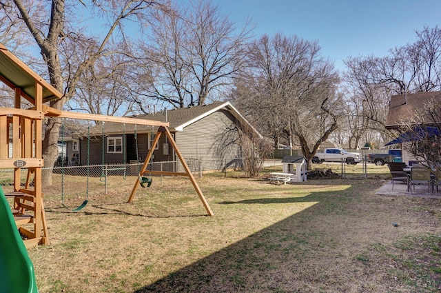 view of yard featuring an outbuilding, a storage shed, a playground, and a fenced backyard