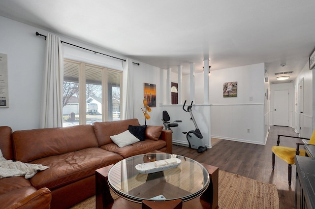 living area with visible vents, baseboards, and wood finished floors