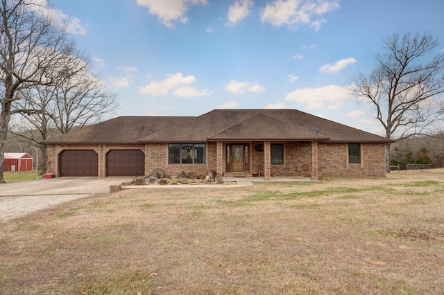 view of front of home with driveway, a front yard, a shingled roof, a garage, and brick siding