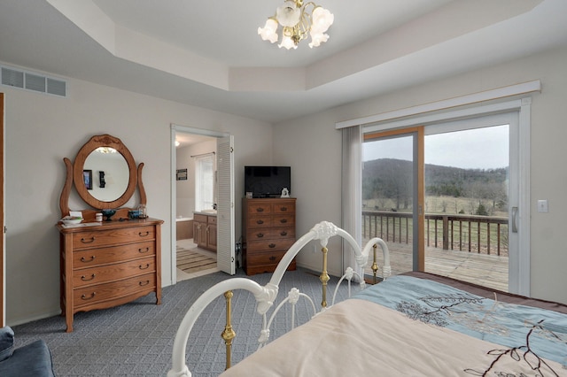 carpeted bedroom with visible vents, ensuite bathroom, an inviting chandelier, a raised ceiling, and access to exterior