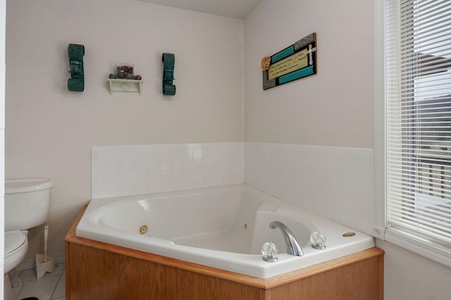 full bath featuring tile patterned flooring, a tub with jets, and toilet