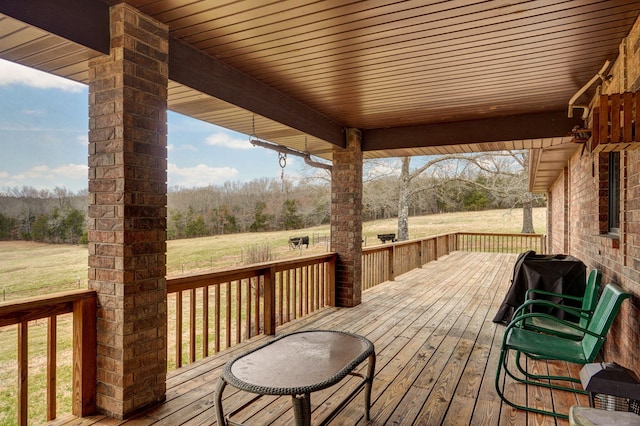 wooden terrace with a yard and grilling area