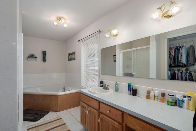 bathroom featuring vanity, a garden tub, a stall shower, a spacious closet, and tile patterned floors