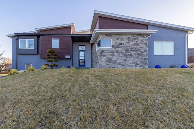 view of front facade featuring stone siding, brick siding, and a front yard