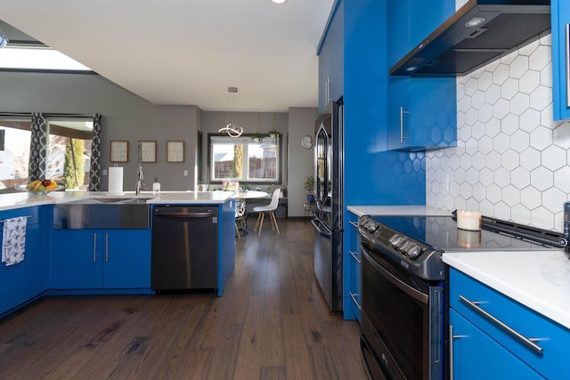 kitchen with blue cabinetry, dishwasher, range with electric stovetop, and wall chimney range hood