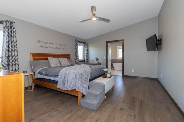 bedroom with baseboards, lofted ceiling, hardwood / wood-style flooring, ensuite bath, and a ceiling fan