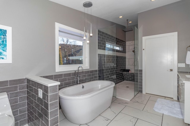 bathroom with marble finish floor, recessed lighting, tile walls, tiled shower, and a soaking tub