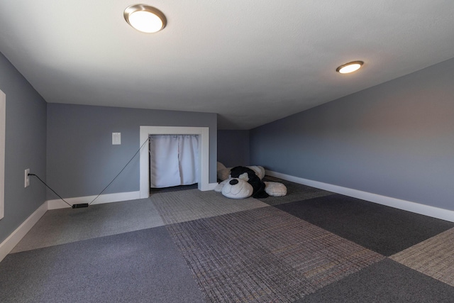 additional living space with baseboards and carpet floors