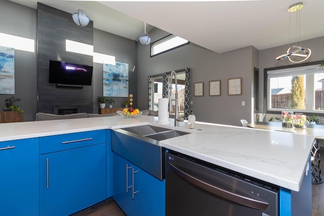 kitchen with blue cabinets, stainless steel dishwasher, pendant lighting, and open floor plan