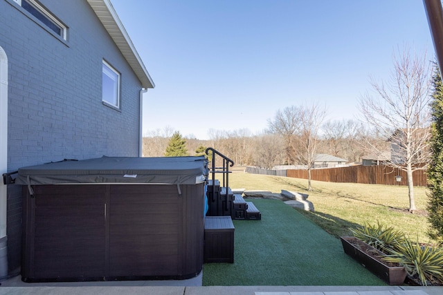 view of patio featuring fence and a hot tub