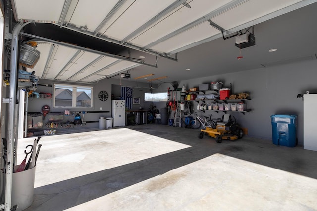 garage with a garage door opener and freestanding refrigerator