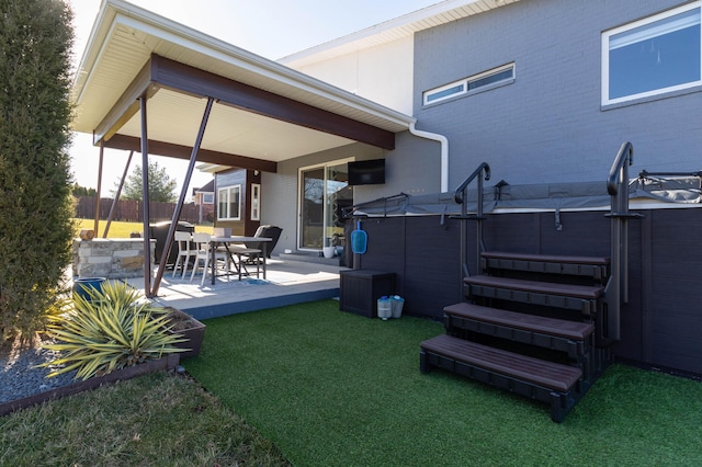 view of yard with a patio, fence, and a hot tub