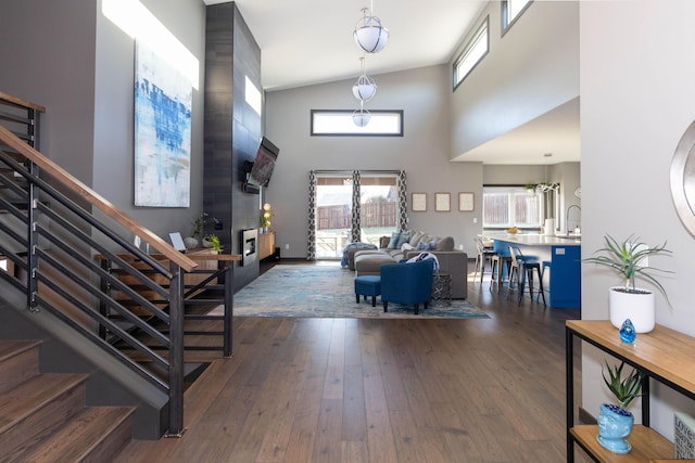 entrance foyer with dark wood-type flooring, stairway, and a towering ceiling