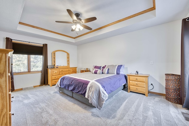 bedroom featuring baseboards, a raised ceiling, light carpet, and visible vents