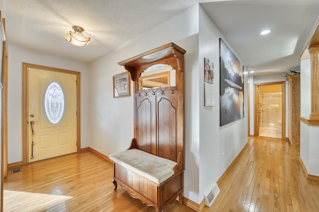 entrance foyer with light wood-style floors, visible vents, and baseboards