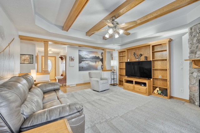 living room with visible vents, baseboards, beam ceiling, a fireplace, and a ceiling fan