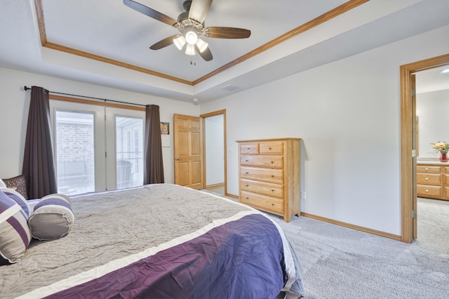 bedroom with access to exterior, light colored carpet, and a raised ceiling