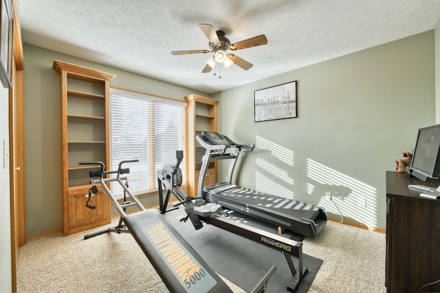 workout room featuring ceiling fan, carpet flooring, baseboards, and a textured ceiling