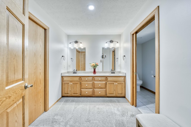 full bathroom with a sink, toilet, and a textured ceiling