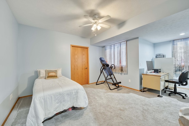 carpeted bedroom with a ceiling fan, baseboards, and a textured ceiling